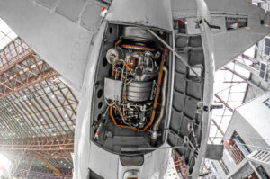 Aircraft auxiliary power unit visible inside an open APU compartment.